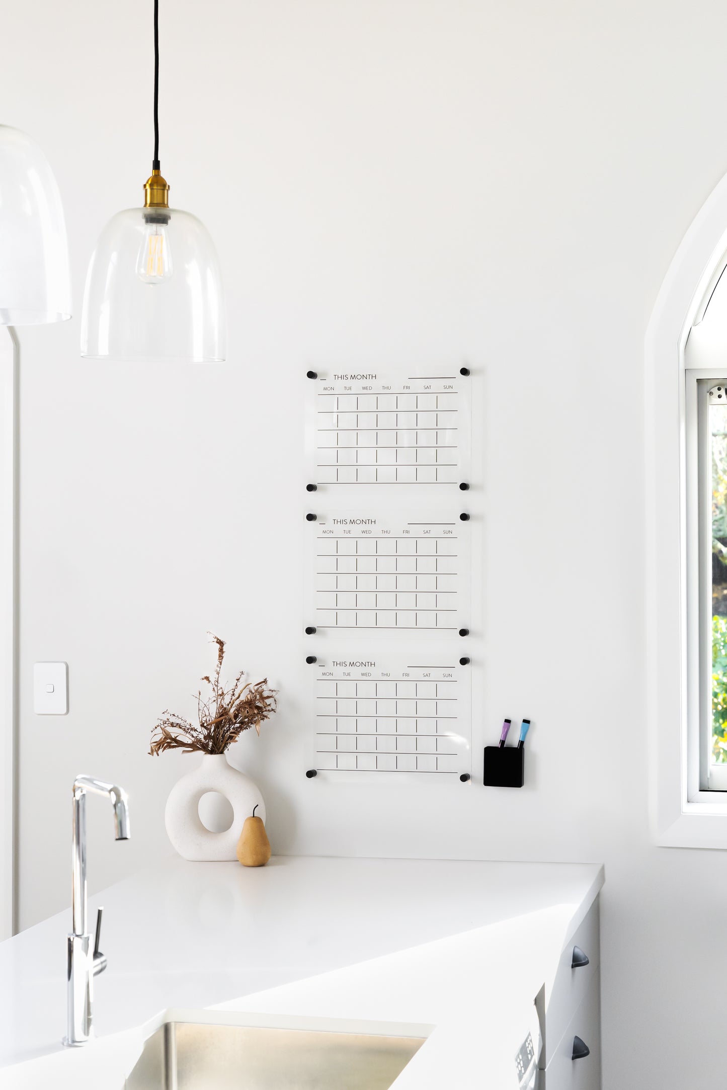 Triple month acrylic wall planner mounted on a white wall, designed for family scheduling and shift work organisation
