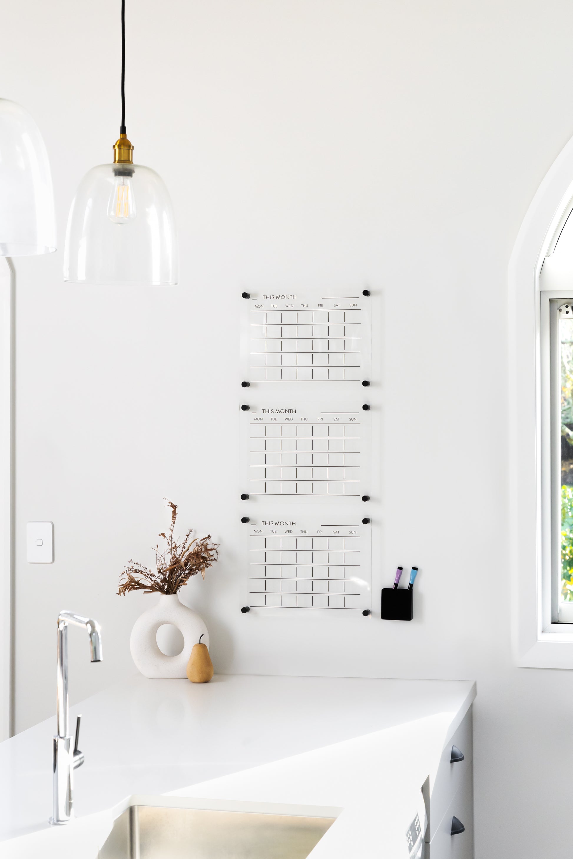 Triple month acrylic wall planner mounted on a white wall, designed for family scheduling and shift work organisation
