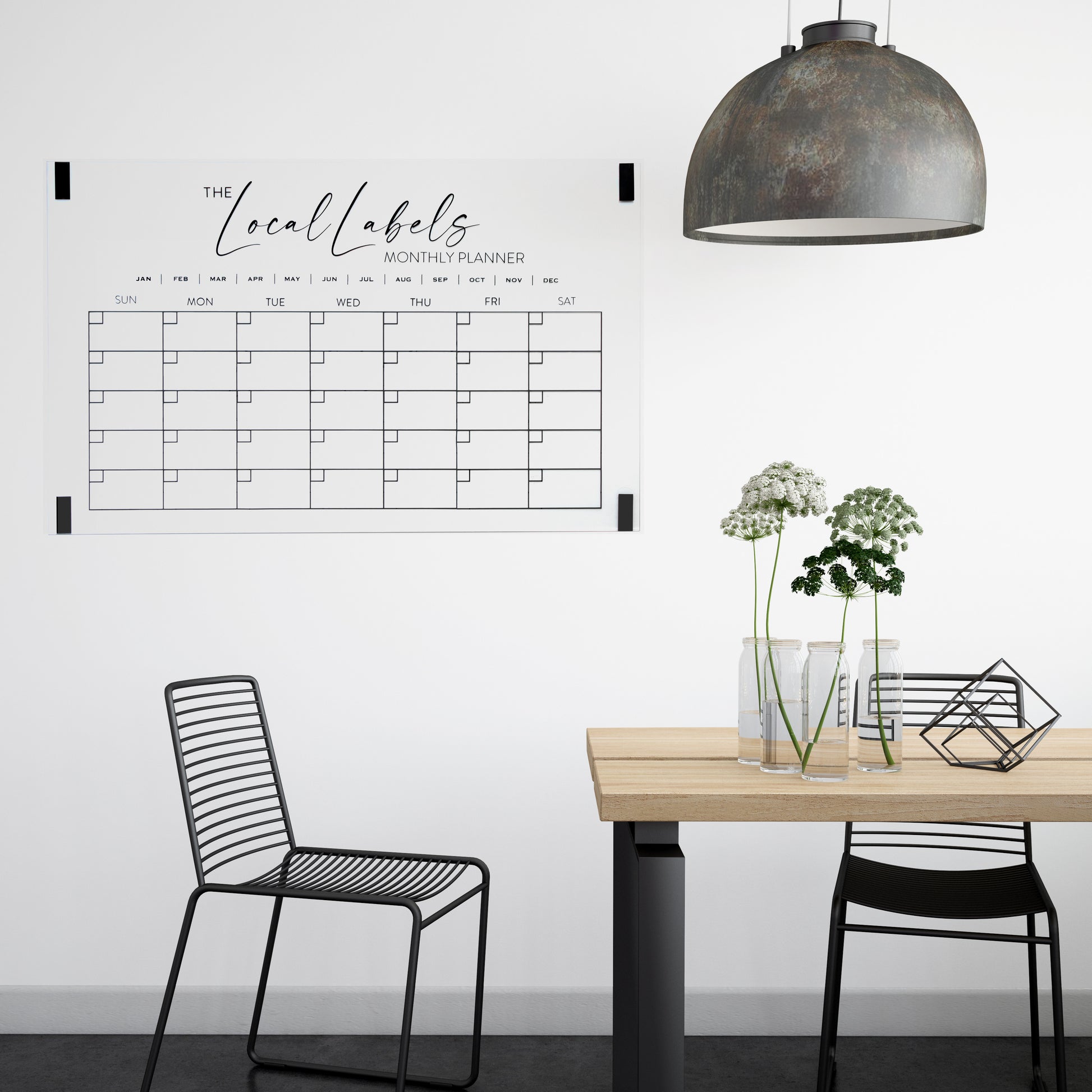 Large black acrylic monthly wall calendar mounted in a dining room using command strips, combining style and functional home organisation.